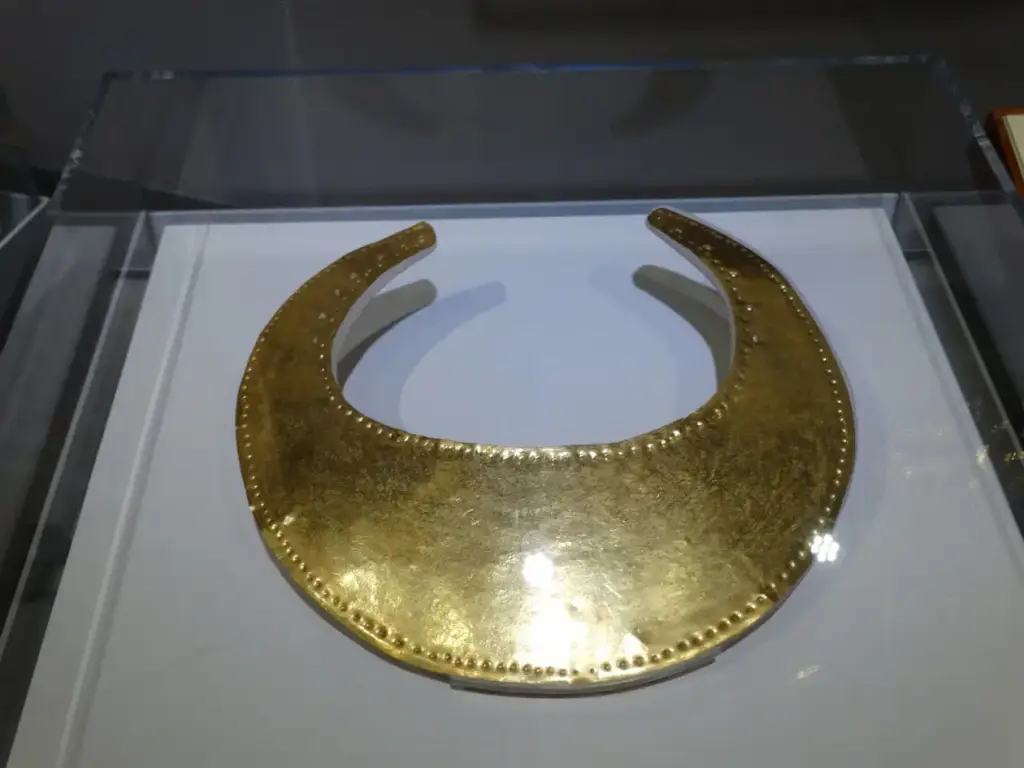 Un collier en or présenté sur un fond sombre