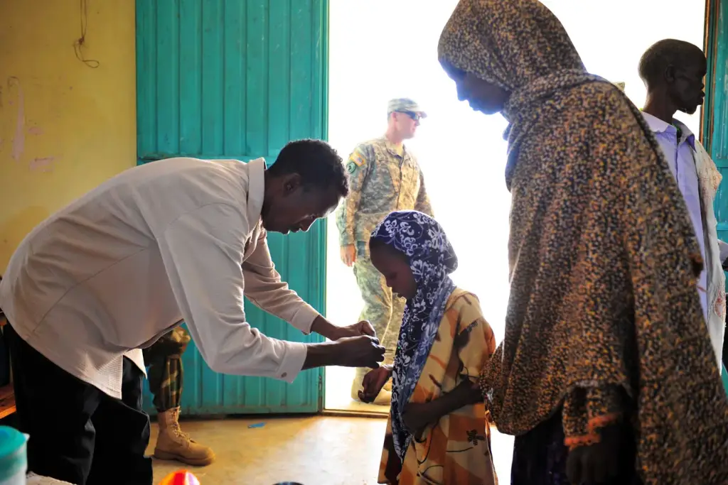 Un agent de santé administre un traitement à une enfant lors d’une campagne contre la schistosomiase en Afrique