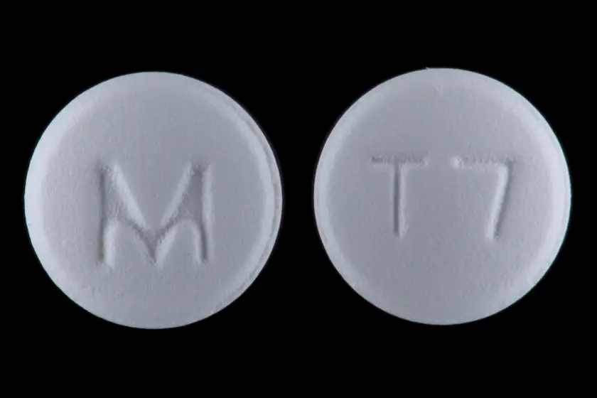 Deux faces d’un comprimé blanc de tramadol photographié sur fond noir
